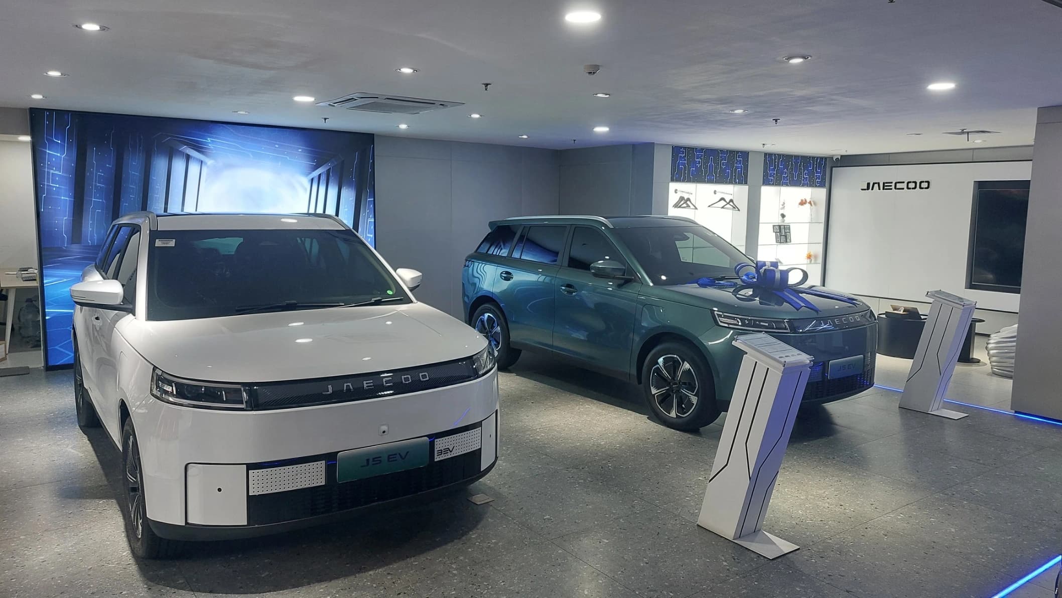 Jaecoo J5 EV Premium putih dan hijau di showroom, dengan harga OTR Jakarta terbaru Rp329.900.000 pada pembaruan Oktober 2026